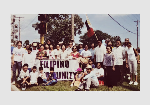 An old photograph showing Komoni founder (far right) affirming connections with the Filipino community during a celebration.