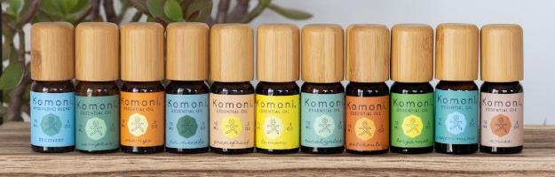 A complete lineup of Komoni's 100% Pure Essential Oils in colorful 10 mL bottles with beautiful bamboo wood tops.