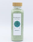 Light green crystals of IMMUNITY Bath Soak in 18 oz. clear plastic bottle with bamboo wood top.