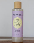 Wood top 8 oz. pastel-purple bottle of Nourish Botanical Shampoo with lavender and other essential oils for all hair types.