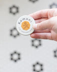 Pocket-sized salve held in fingertips fits comfortably in the palm of your hand.