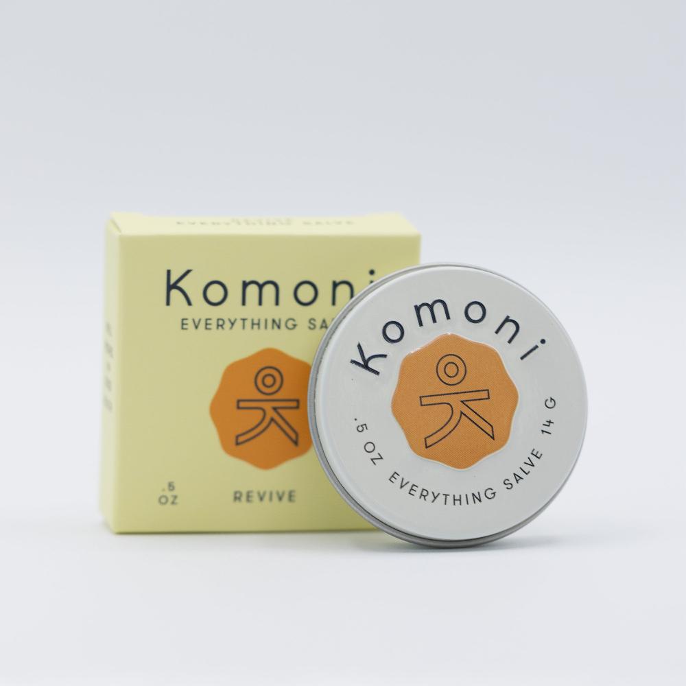 Lemongrass and Orange essential oil REVIVE everything lips, hands, skin salve shown in tin in front of box. Offers a nourishing blend of beeswax, organic sunflower oil, and shea butter. 