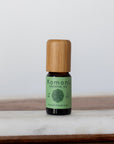 Rosemary pure essential oil in 10 mL bottle with bamboo wood top.