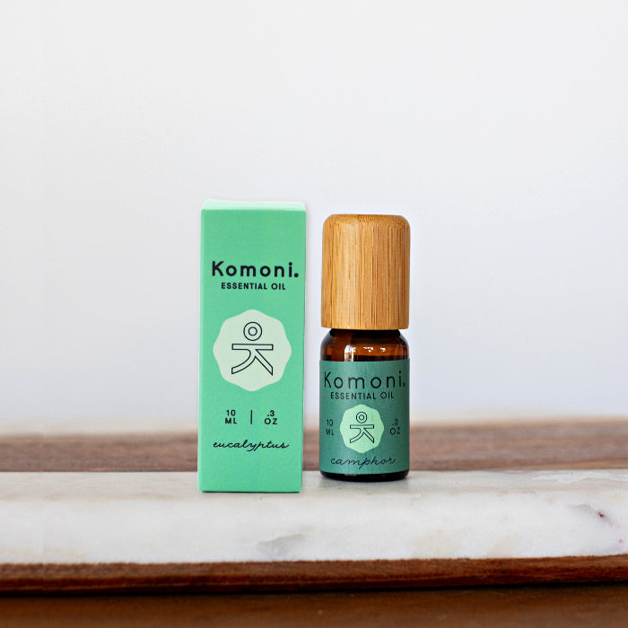 Camphor pure essential oil in 10 mL bottle with bamboo wood top next to box packaging.