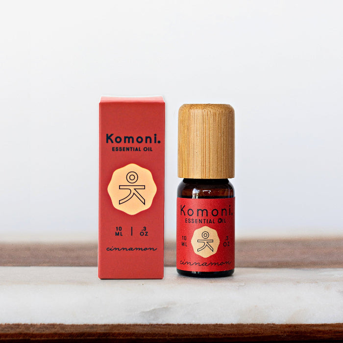 A 10ml vial of Cinnamon pure essential oil with attractive bamboo wood top next to box packaging.