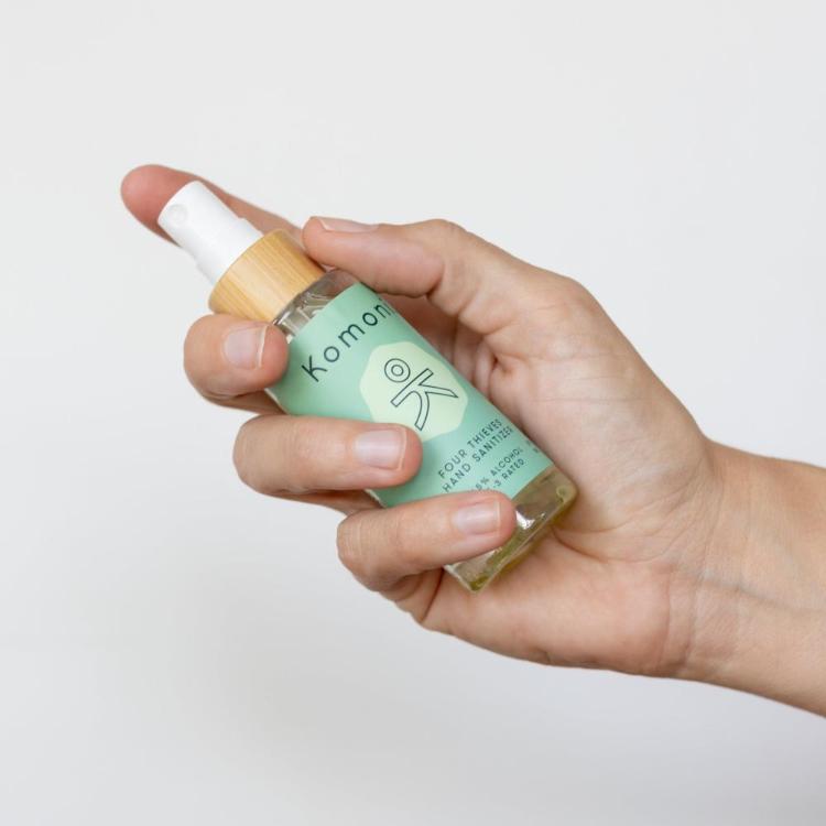 A hand shown holding a spray 2 oz. bottle of Four Thieves E3 rated hand sanitizer formulated with 65% ethyl alcohol to effectively kill harmful germs and bacteria, it also contains moisturizing hempseed oil, which helps the skin retain hydration, reduce inflammation, and improve texture. The antioxidant properties support the skin’s barrier, protecting it from environmental damage while leaving your hands soft and smooth. 