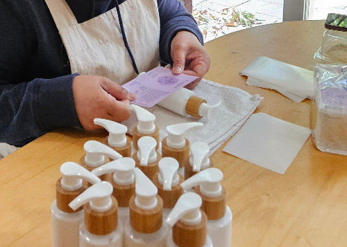 Putting labels on the bottles of botanical lotion.