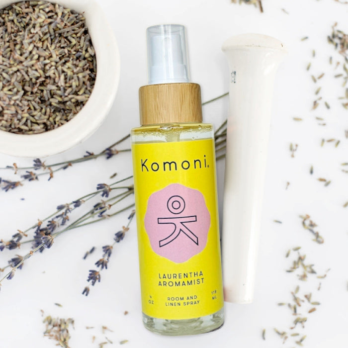 4 oz. spray bottle of Laurentha Aromamist in front of plant-based ingredients.