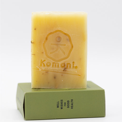 Hand stamped, rough cut lemongrass essential oil face and body bar on top of its box packaging.