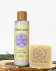 8 oz. pastel yellow bottle of Nourish lavender essential oil conditioner next to Nourish Shampoo bar for all hair types.