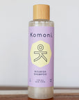 Wood top 8 oz. pastel-purple bottle of Nourish Botanical Shampoo with lavender and other essential oils for all hair types.