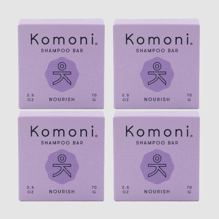 Four lavender colored boxes of Komoni eco-friendly, concentrated NOURISH Essential Oil Shampoo bars shown in a grid.