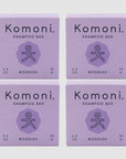 Four lavender colored boxes of Komoni eco-friendly, concentrated NOURISH Essential Oil Shampoo bars shown in a grid.