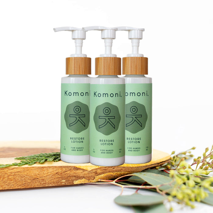 3 wood top 4 oz. pastel green pump-bottles of RESTORE pure botanicals & essential oils hand & body lotion.