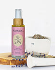 4 oz. spray bottle of Sofia Aromamist beside plant-based ingredients.